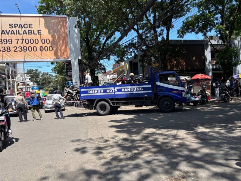 Petugas Dishub Kota Bandung bersama TNI-Polri melakukan penderekan mobil yang parkir liar di bahu jalan pusat kota